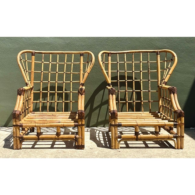 Exuding mid-century resort elegance and dramatic architectural presence, this pair of vintage high-back lounge chairs...