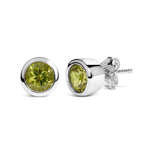 Immerse yourself in the vibrant allure of these exquisite stud earrings, each featuring a lab-created, color-treated green...