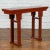 A Chinese Qing Dynasty period elmwood altar console table from the 19th century, with red lacquer and carved apron....