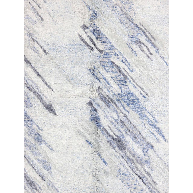 Hand-knotted Modern rug featuring an abstract, painterly design with diagonal striations across a soft ivory field. Subtle...