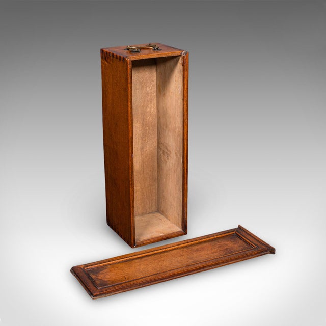 This is an antique wine bottle case. An English, walnut and brass Champagne Magnum box, dating to the Regency period,...