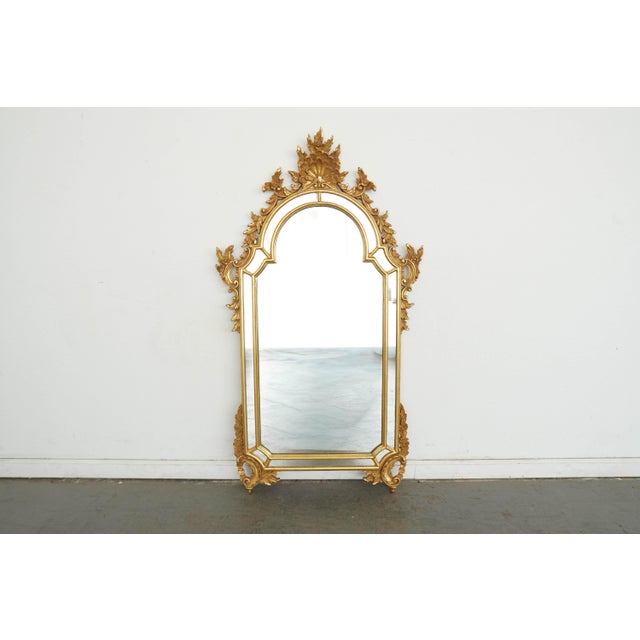 Elegant vintage La Barge wall mirror featuring an ornate giltwood frame with beautifully detailed scrolling foliage and...