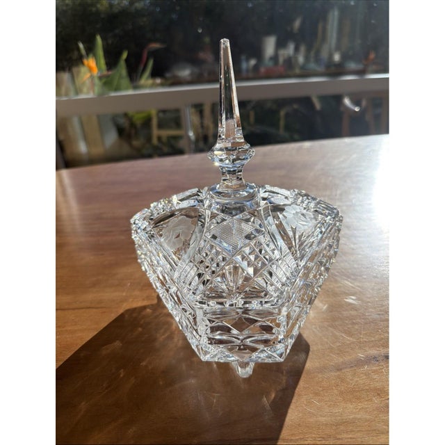 This vintage crystal triangle dish with lid and finial top is a unique and charming piece of American decor. Made of clear...