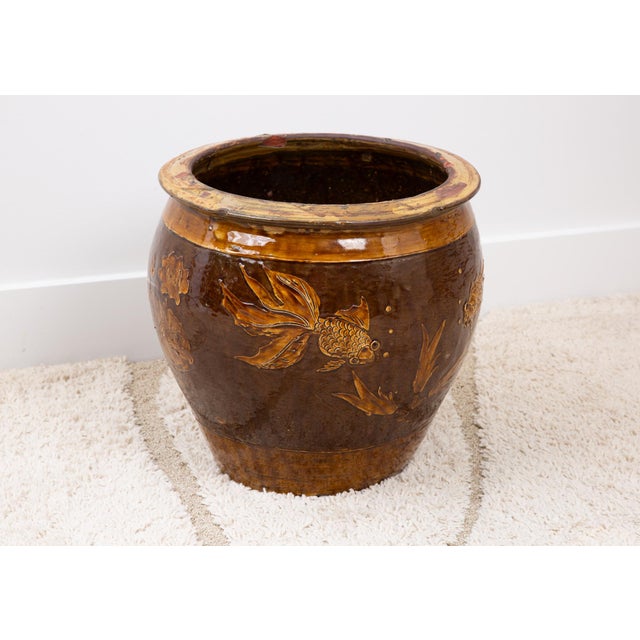 Mid-Century Chinese brown glazed pot with goldfish and lily pad relief design. Good vintage condition with some flaws...