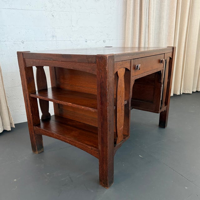 This Arts & Crafts desk circa the 1920s beautifully showcases the honest craftsmanship and geometric precision of the Arts...