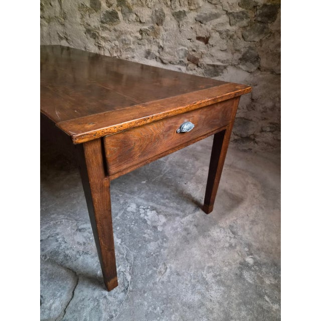 An antique French farmhouse dining table dating from around 1850–1900. The table has a solid oak base with a pine top and...