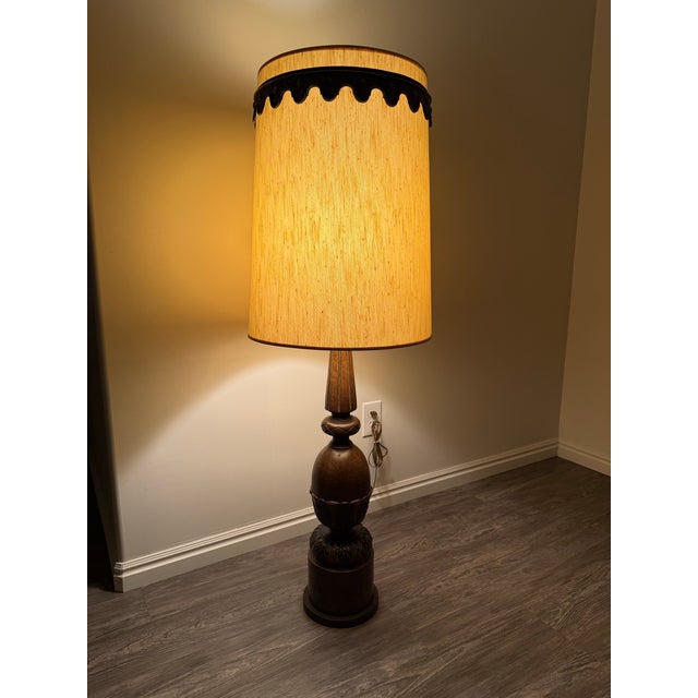 Striking oversized vintage carved wood table lamp featuring a richly detailed dark brown finish and an impressive...