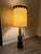 Striking oversized vintage carved wood table lamp featuring a richly detailed dark brown finish and an impressive...