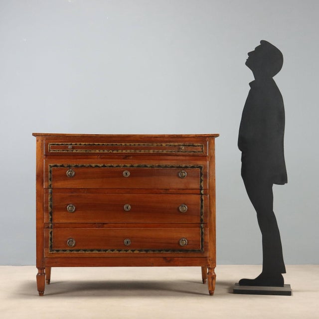 Directoire chest of drawers made of walnut, dating back to the early 19th century in Italy. The structure features a front...