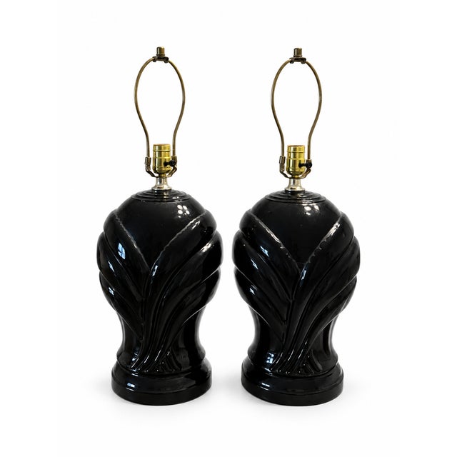A dramatic pair of vintage black ceramic table lamps featuring deeply sculpted, sweeping leaf-like forms and a high-gloss...