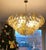 This chandelier consists dozens of hand blown gray , amber and clear "Poliedri" made of Murano glass with a brass frame....