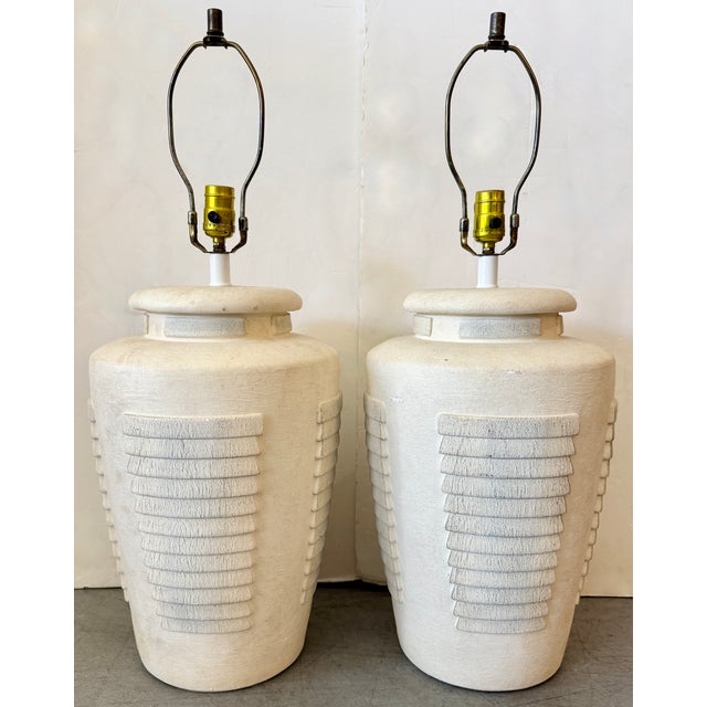 Pair of vintage 1980s plaster lamps. They feature a stacked ribbed design in an off-white finish.These lamps are designed...