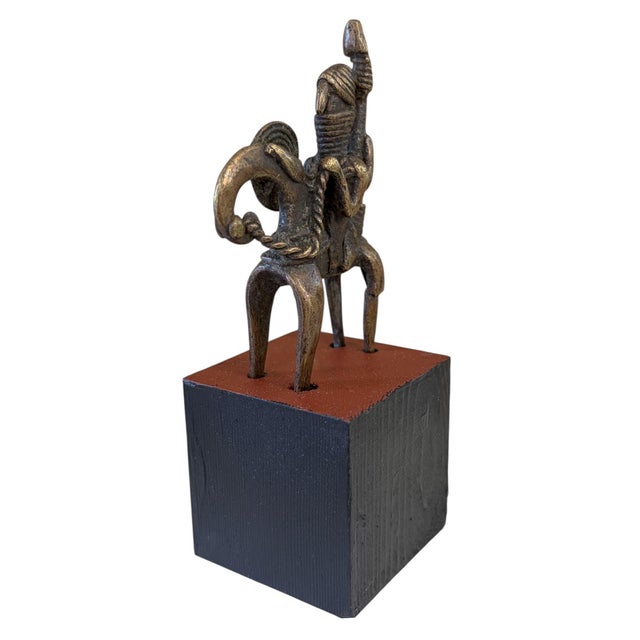 This vintage Dogon bronze equestrian figure on a black wooden stand is a mrammuo—a traditional gold weight—measuring 4.75"...