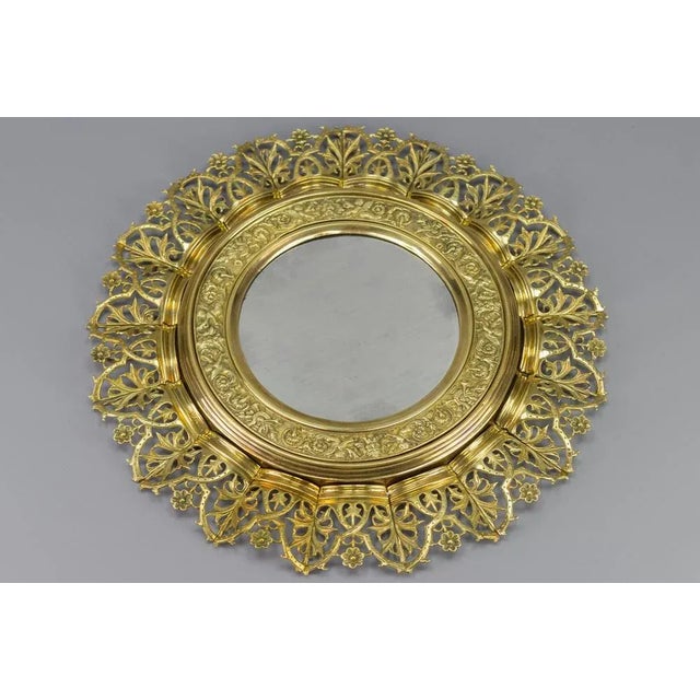 - A stunning circular wall mirror in a sunburst shape. - This antique mirror features an embossed brass and bronze frame...