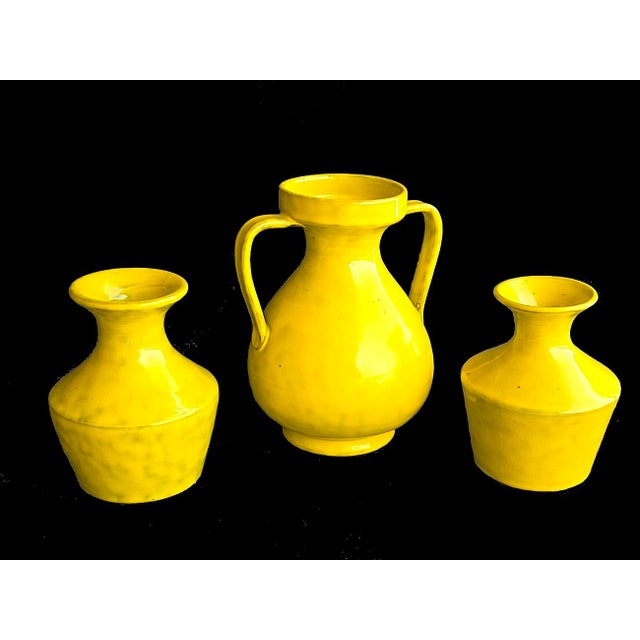 Offered is a set of 3 ceramic vases in a sunny lemon yellow designed by Aldo Londi for Bitossi in the 1960s and...