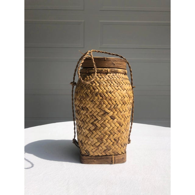 Substantial rattan basket in herringbone pattern with bent-wood frame lid, bent-wood base and woven rattan transportation...
