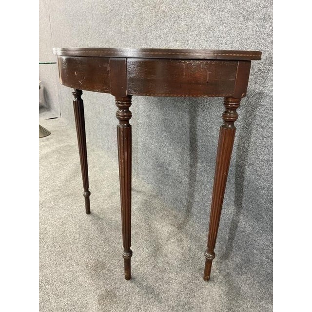 Antique Sheraton Style Demilune Console Table with beautiful mahogany veneer and contrasting inlaid banding detail. This...