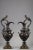 Pair of decorative ewers in bronze with two patinas in the Renaissance taste. The handles are in the form of busts of nude...
