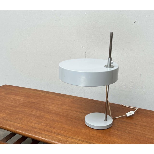 Rare mid-century table lamp. A minimalist design with a clean, understated aesthetic. The shade is shaped like a flat...