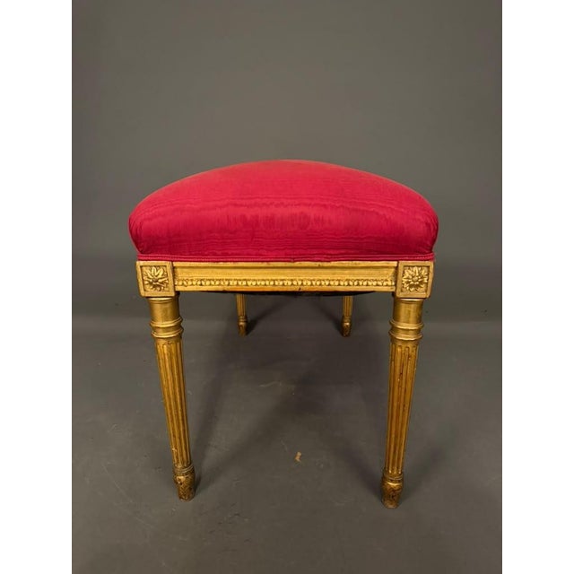 An elegant 19th-century French Louis XVI-style gilded bench, circa 1890, featuring a beautifully carved wood frame, a...
