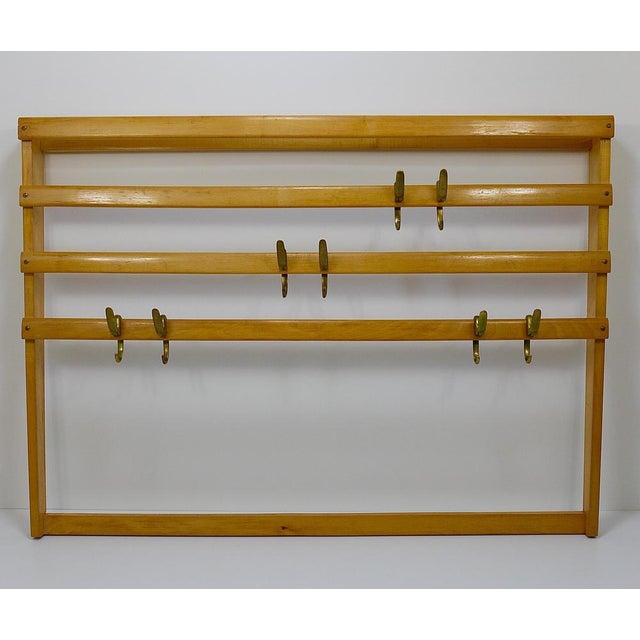 An elegant modernist wall-mounted coat rack from the 1950s. An original and old vintage object, designed and manufactured...