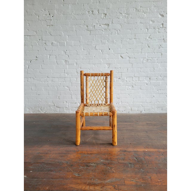 Vintage rustic rough-hewn log pole and hand woven raw hide side chair. In excellent condition. 16"W x 19"D x 30"H