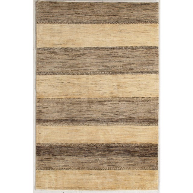 Hand-knotted Persian Lori Gabbeh rug featuring a field composed of horizontal bands in tonal beige and brown, with subtle...