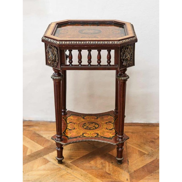 A high side table in the classicist style of Louis XVI decorated with rich marquetry and bronze applications. Beneath the...