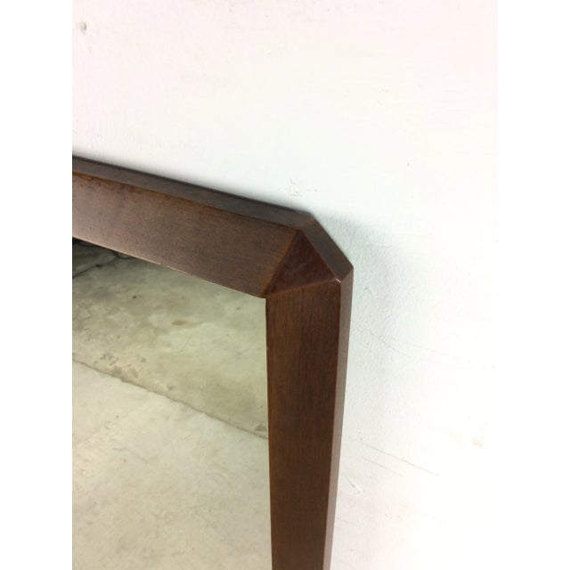 This mid century modern mirror features hardwood frame, original walnut finish, angular frame, and partial mounting hardware.
