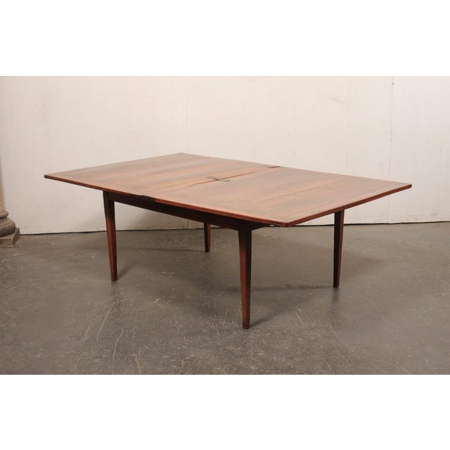 A French wooden dining table, with expandable flip-top, from the 19th century. This antique table from France has a...