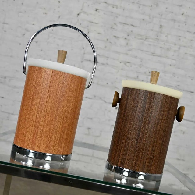 Lovely pair of vintage mid-century modern Kromex ice buckets. Both woodgrain textured metal buckets 1 lighter with a bail...