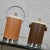 Lovely pair of vintage mid-century modern Kromex ice buckets. Both woodgrain textured metal buckets 1 lighter with a bail...