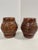 A pair of hand carved wooden hollow barrel-form garden stools in a warm reddish-brown finish with removable tops, a flat...
