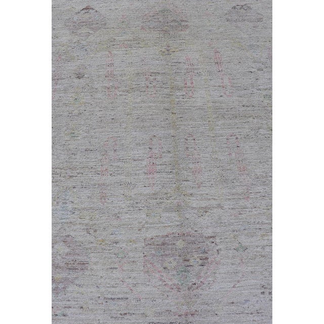 Measures: 5'1 x 6'9. This modern casual muted tribal rug has been hand-knotted. The rug features a modern sub-geometric...