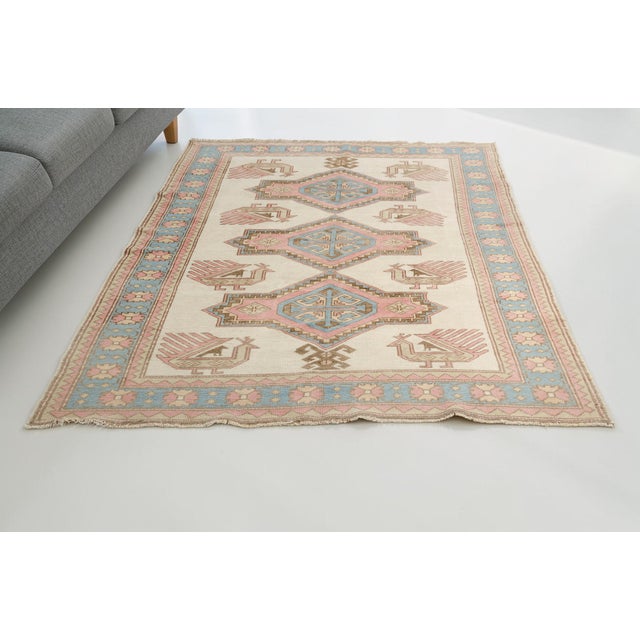 Infuse your space with playfulness and character using this delightful vintage Turkish rug. Featuring a cream-colored...