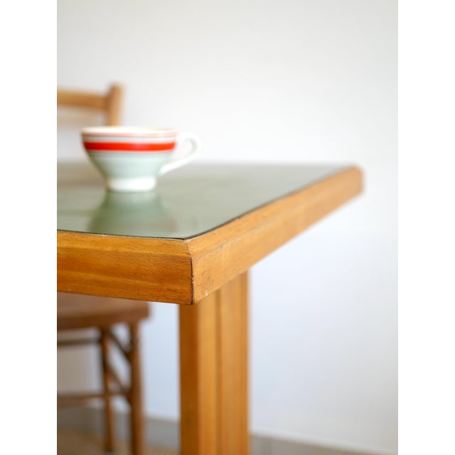 A bistro set comprising a rectangular table and two bentwood chairs. The beechwood table features an olive green formica...