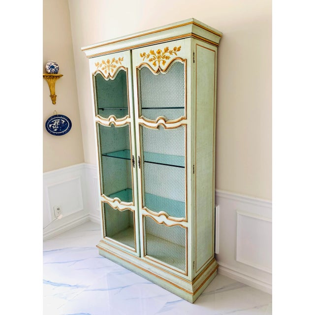 A beautiful vintage c. 1940s Italian Florentine celadon china cabinet, richly hand-decorated with gold-tone painted floral...