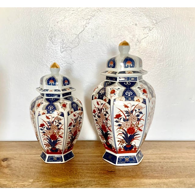 Set of two octagon shaped porcelain ginger jars with floral decoration and gilt accenting Larger : 6” dx 12” h Smaller: 6”...