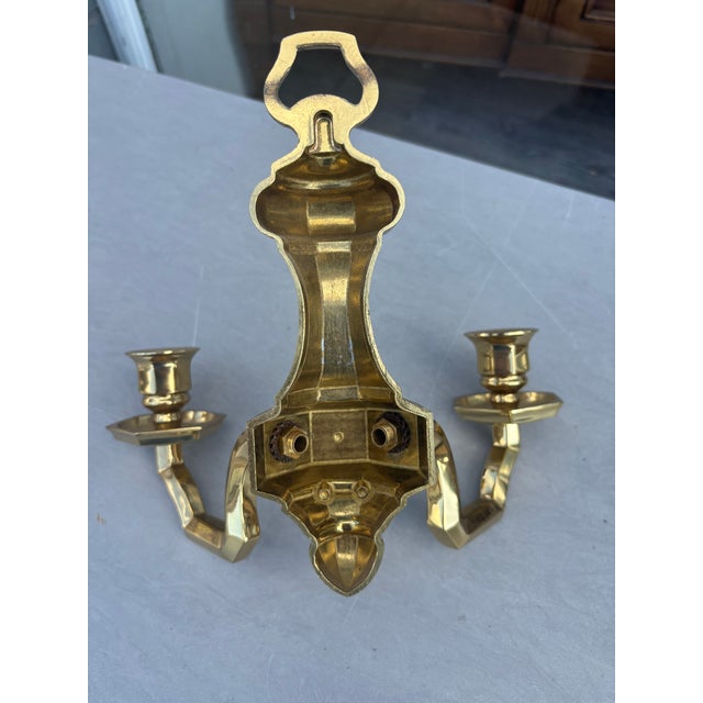 Pair of brass cubist sconces . Each sconce has a double arm .