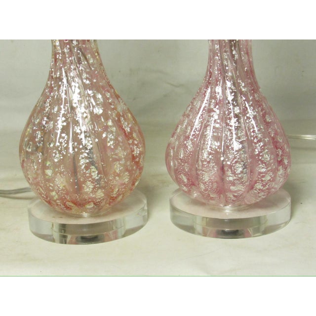 Pair of small scale Murano art glass lamps, c.1950’s Having a ribbed globular shape with a pink hue, and fleks of silver...