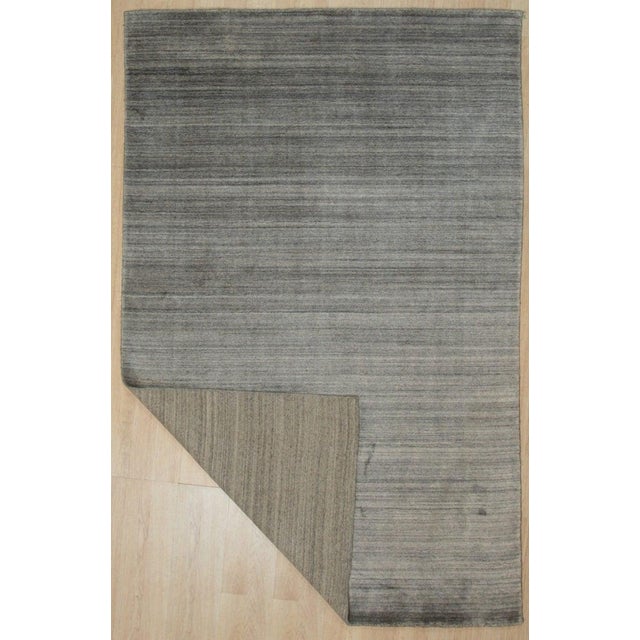 This gray hand knotted pile rug is crafted from a blend of wool and viscose. The contemporary design offers a solid and...