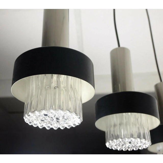 Very beautiful elegant 3-fold pendant lamp from the 60s. Ceiling fixture made of black painted and chromed metal. 3...