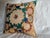 A decorative pillow created from a 1900s hand-embroidered Suzani textile, featuring a bold central medallion encircled by...