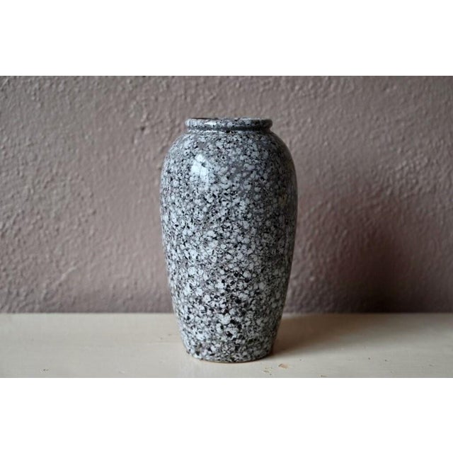 A glossy glaze that perfectly imitates marble and its inlays, along with an elegant shape, characterizes this lovely...