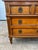 Elegant French 19th-century Louis XVI walnut commode featuring three drawers, paneled fronts, carved fluted sides,...