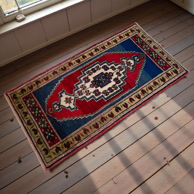Vintage Turkish hand-knotted small rug from Tashpinar, Central Anatolia, 1970, featuring warm brick-red and deep indigo...