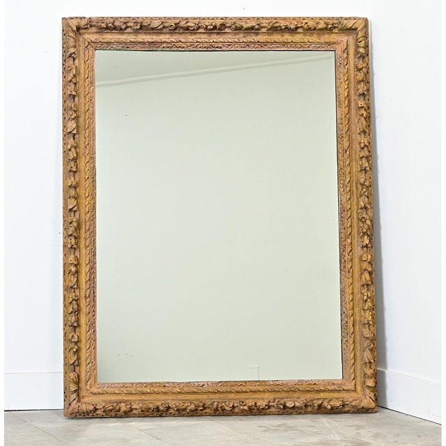 A hand-carved and painted picture frame from 18th century France that has been meticulously restored; it now houses a new...