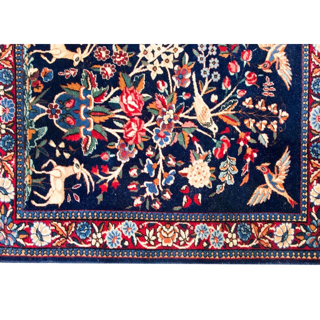 This exquisite antique Persian Kashan rug from the 1920s features a vibrant 'Birds of Paradise' pictorial design. Hand-...