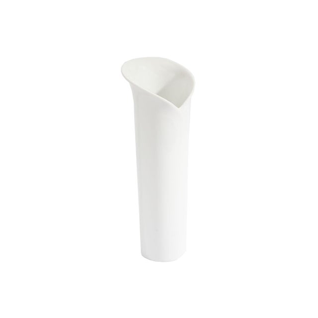 A white porcelain vase produced by Rosenthal. Made in Germany, this slender vase features a calla lily-like rim and is...