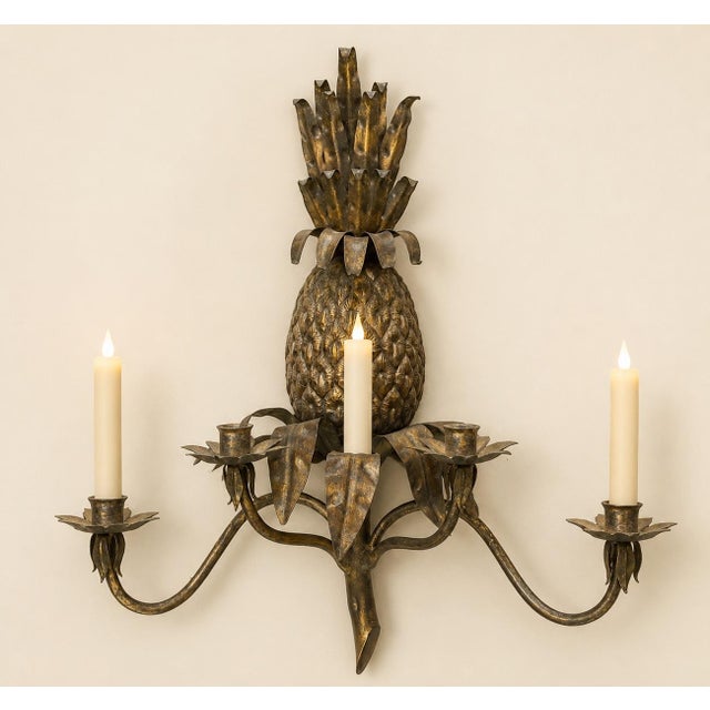 A dramatic vintage four-light wall sconce crafted of heavy iron, featuring a large dimensional pineapple—the traditional...